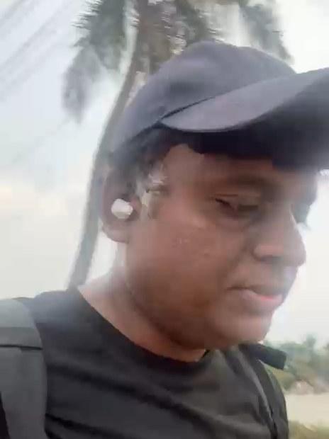 The founder walking along a road lined with palm trees