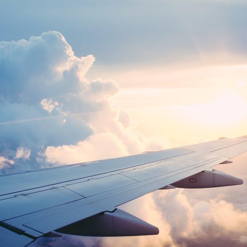 A plane wing above clouds at sunrise